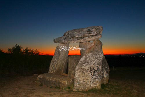 En esta imagen en la denominada en fotografía como hora azul vemos en plano medio el dolmen de Sorginetxe, en plano de fondo la línea del horizonte a partir de la cual el cielo en la parte de abajo tiene un color naranja vivo y la parte superior un azul profundo.