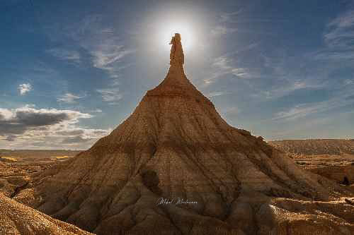 En este contraluz el sol justo queda detrás de la cabeza de esta formación natural de tierra, producto de la fuerte erosión llamada Castildeterra. Esta formación tiene la base en forma de pirámide circular, del centro sube lo que podría parecer un largo cuello que sujeta una especie de cabeza.